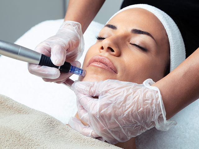 Cosmetologist making mesotherapy injection with dermapen on face